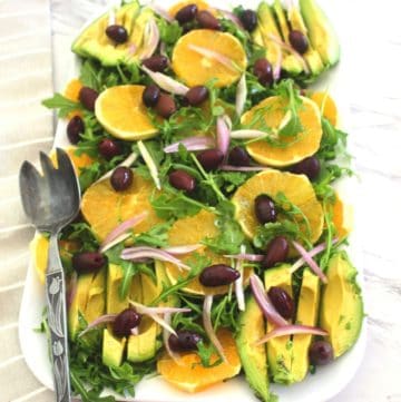 Winter orange salad with kalamata olives, arugula and avocado. This delicious Mediterranean salad is served with a citrus dressing.