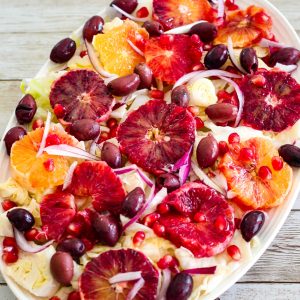 A salad platter with cabbage, blood orange, pomegranates, olives etc.