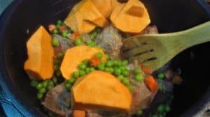 Add chunks of sweet potato to meat and green peas.