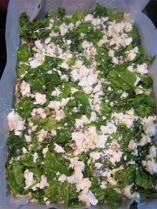 Adding Spinach filling to the corn pie casserole