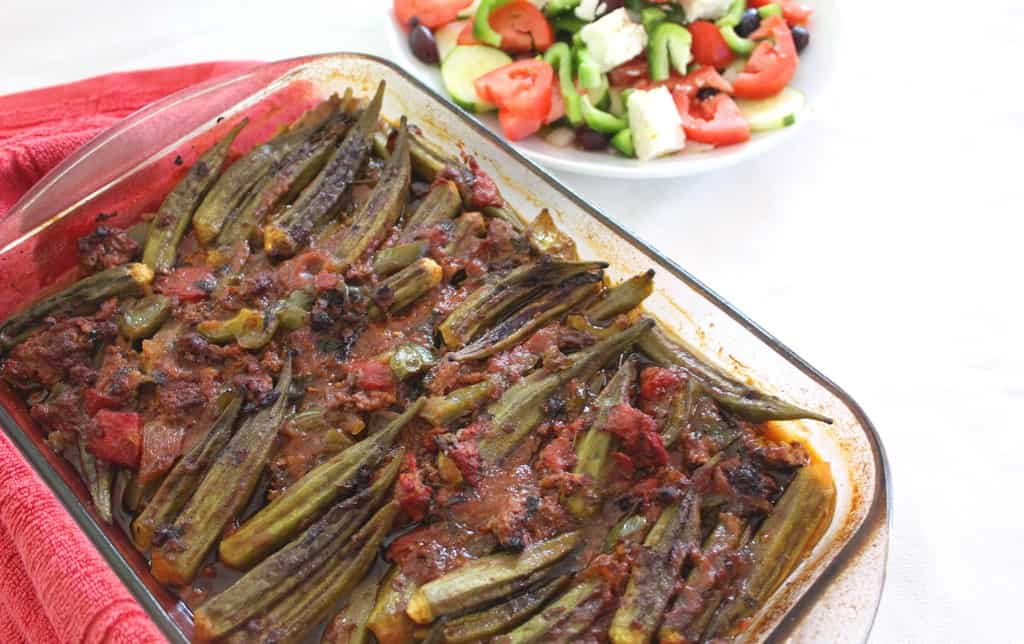 Baking dish just out of the oven with Mediterranean Baked Okra (Tave me Bamje) served with Greek Salad. 