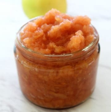 Jar of fresh quince jam shown with a quince fruit in the background