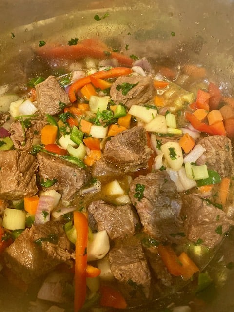Adding beef and stock to the sauteed vegetables