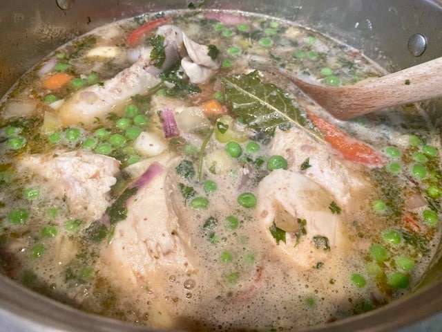 Adding chicken pieces to picana soup pot