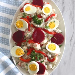 Albanian sallate ruse or russian salad, garnished with egg, beets and parsley.