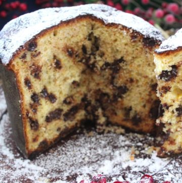 Homemade Christmas Sweet Bread, Panettone. Picture shows a panettone already sliced open, focusing on 3/4 of the bread. Bread is covered in confectioner sugar.