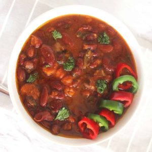 Vegan Red Kidney Beans Soup shown in a soup bowl, topped with sliced jalapenos and red chilis
