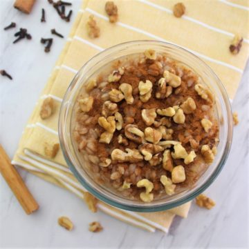 A bowl with farro pudding topped with walnuts and cinnamon