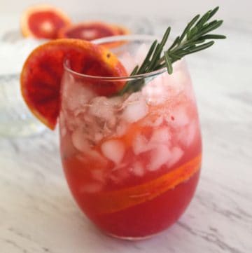 Low carb blood orange vodka cocktail served over crushed ice and decorated with a rosemary twig