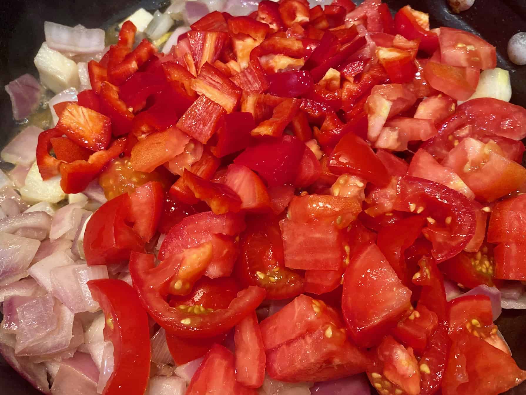 Add diced tomatoes and red pepper to sauteed onion.