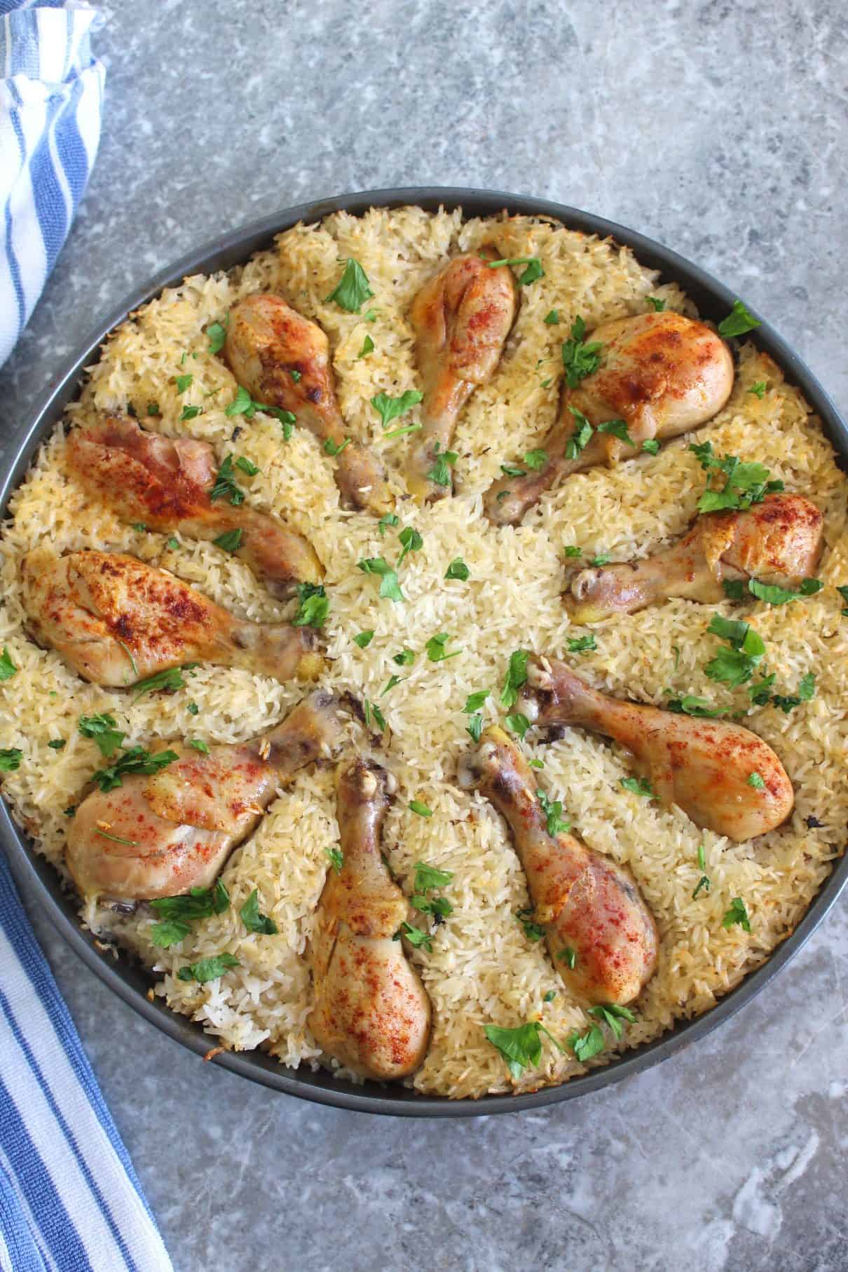 Picture shows a round pot, just baked with a rice dish and chicken drumsticks.
