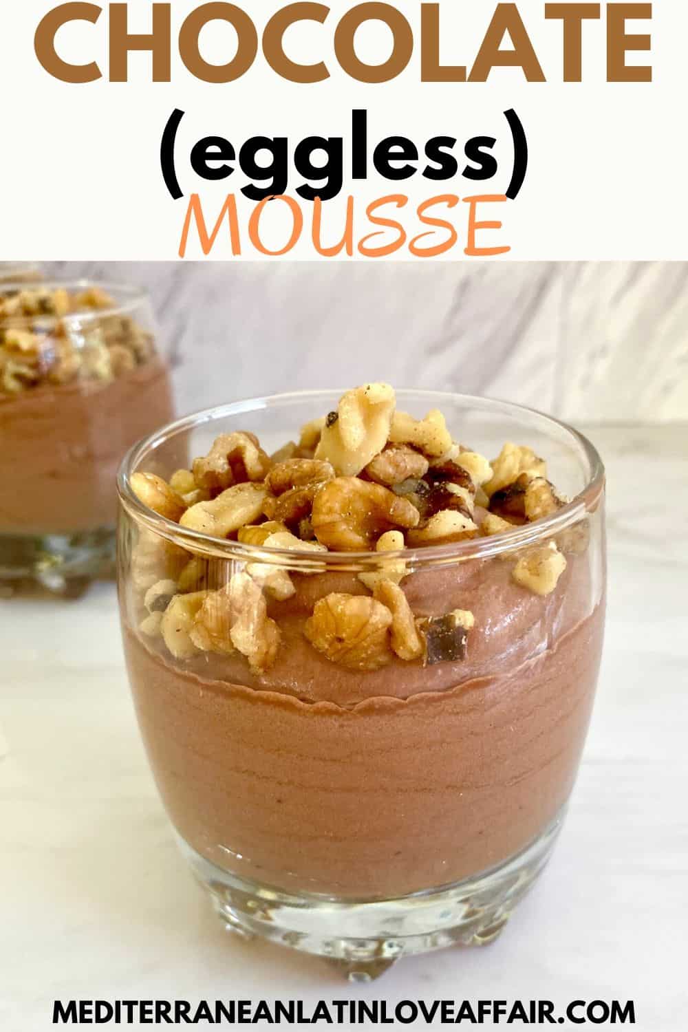 Homemade chocolate mousse topped with chopped walnuts served in a cup on the foreground, you can see other cups in the background.
