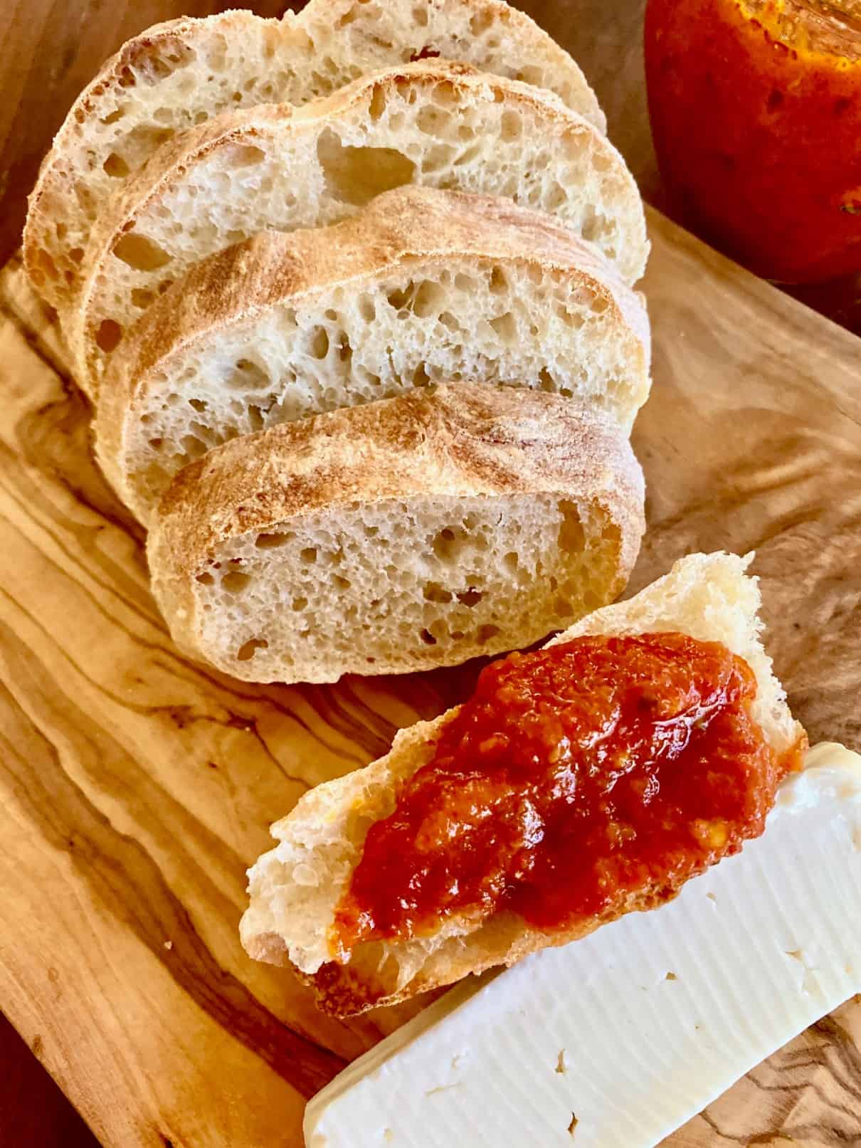 Homemade bread served with ajvar red pepper sauce and cheese. 