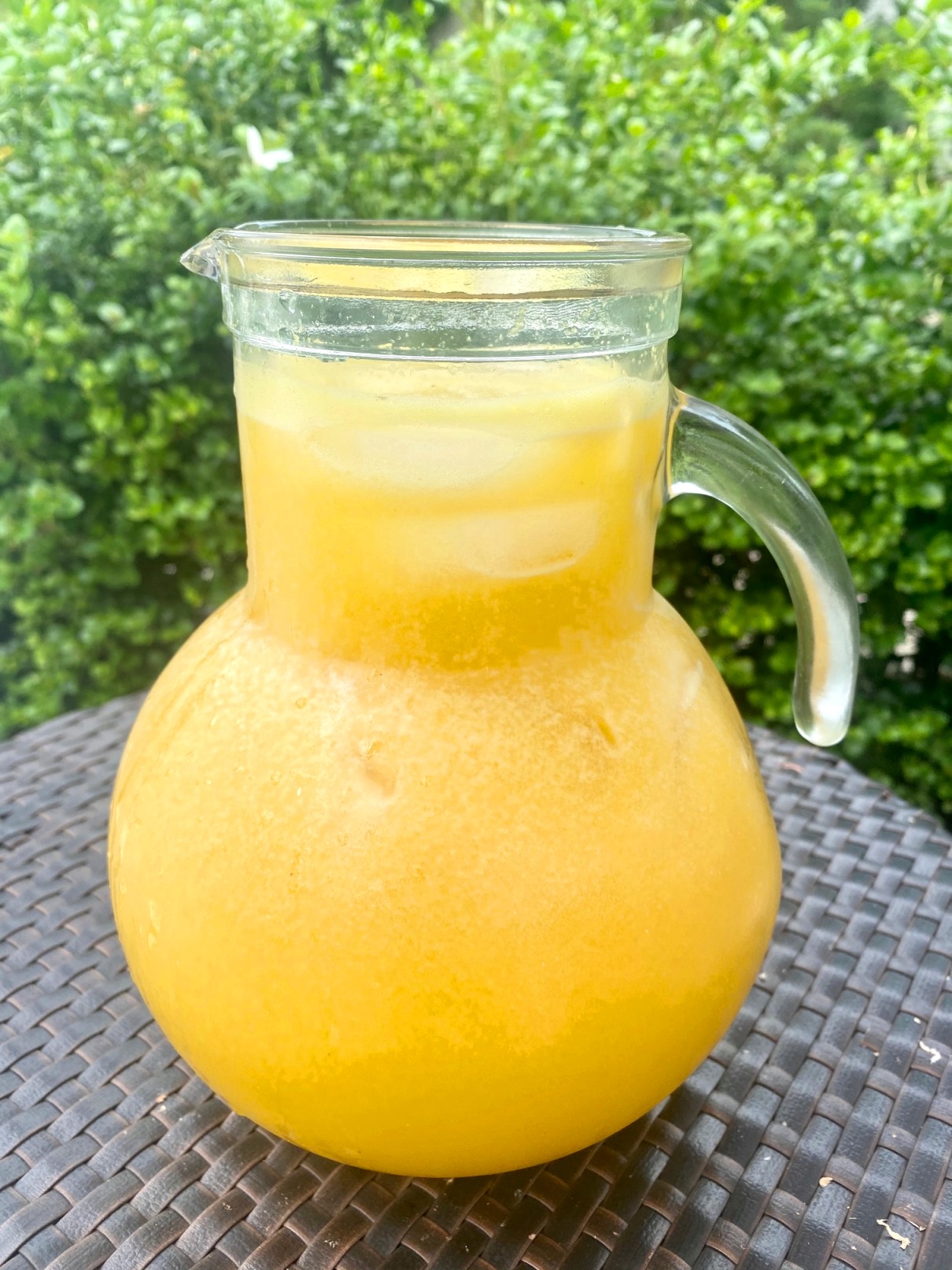 A pitcher of passion fruit (maracuya) mocktail in a table outdoors.