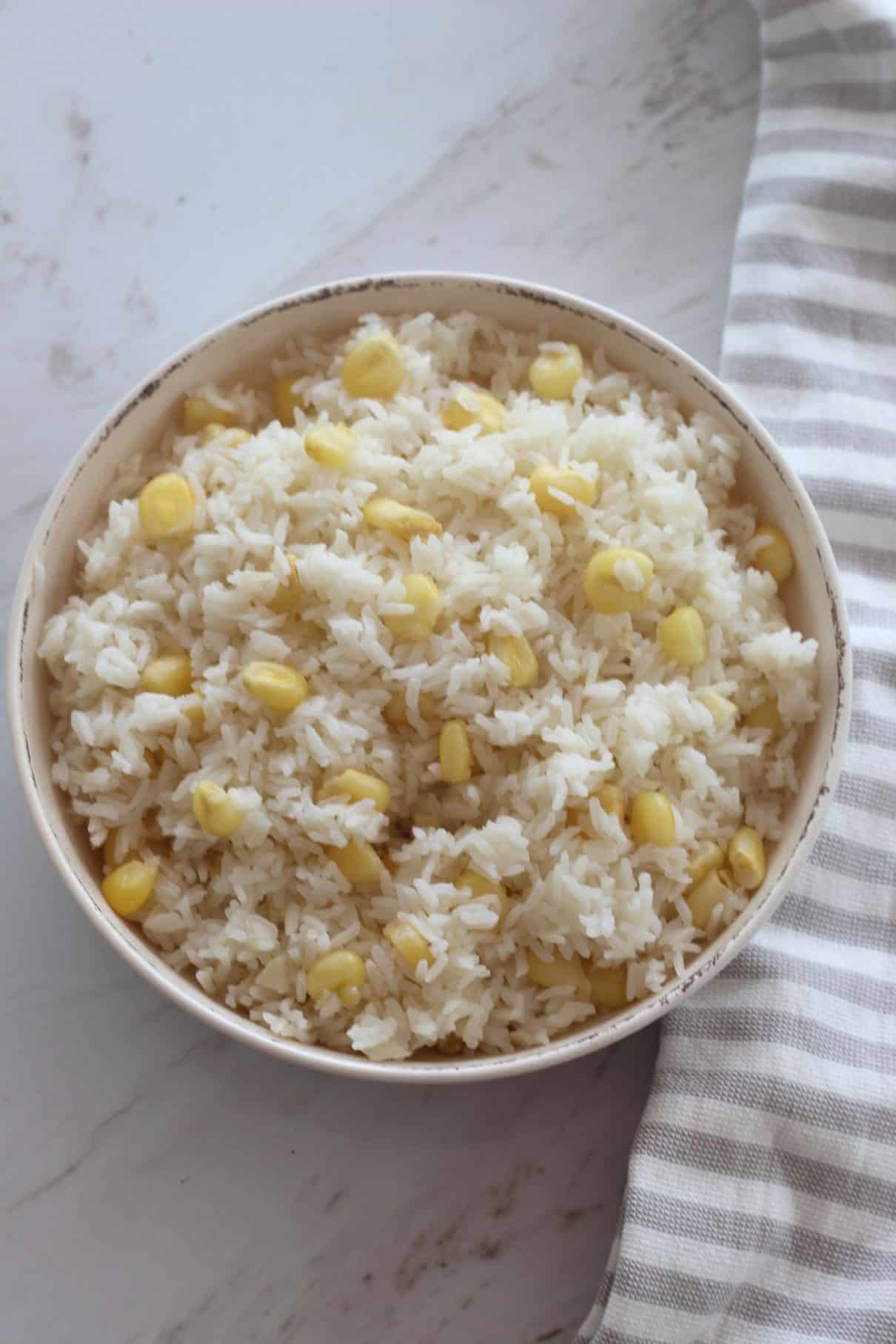 A round dish with fluffy rice and big kernel corn called choclo.
