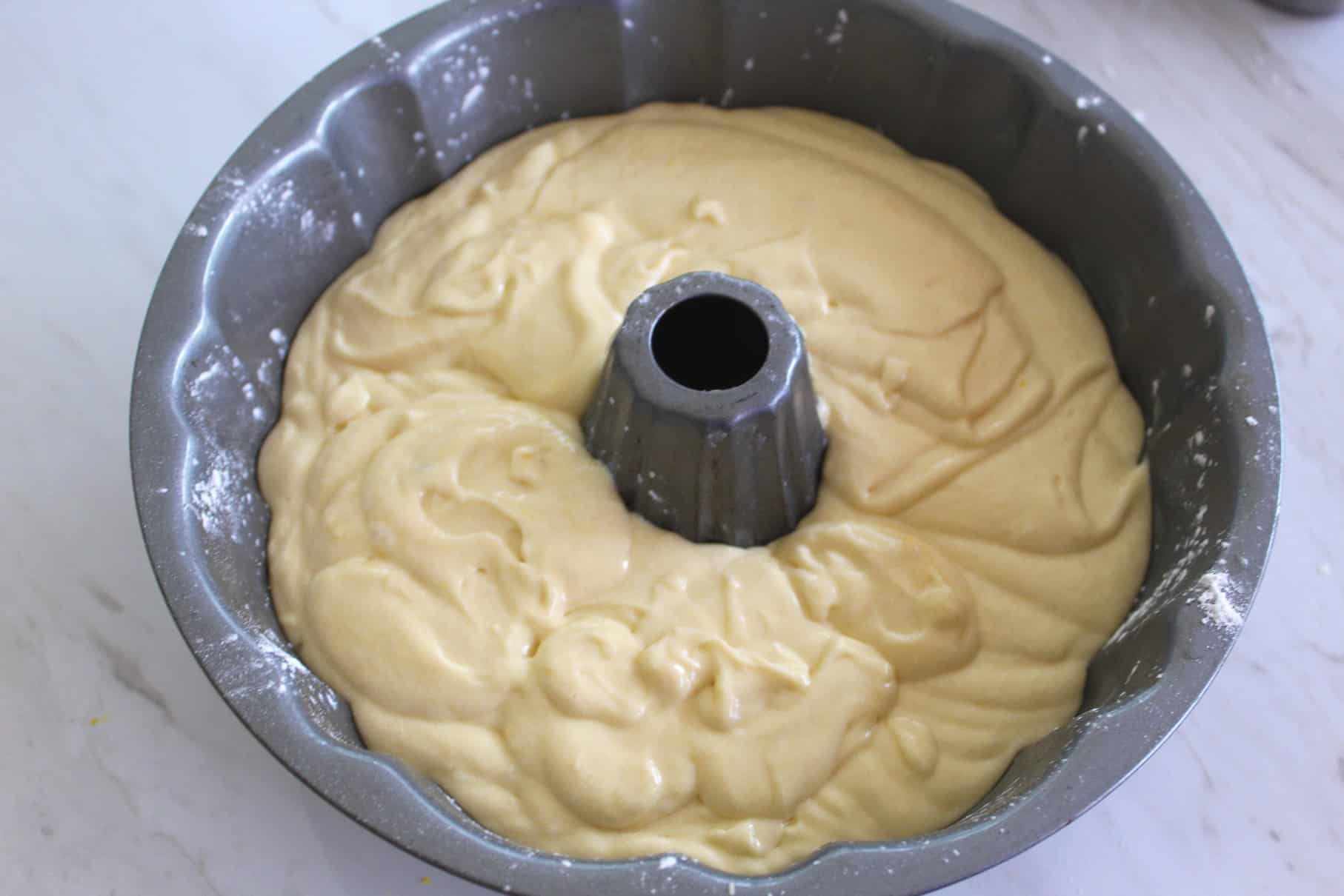 Cake batter in the bundt cake pan. Pan looks to be dusted. It all looks ready to bake.