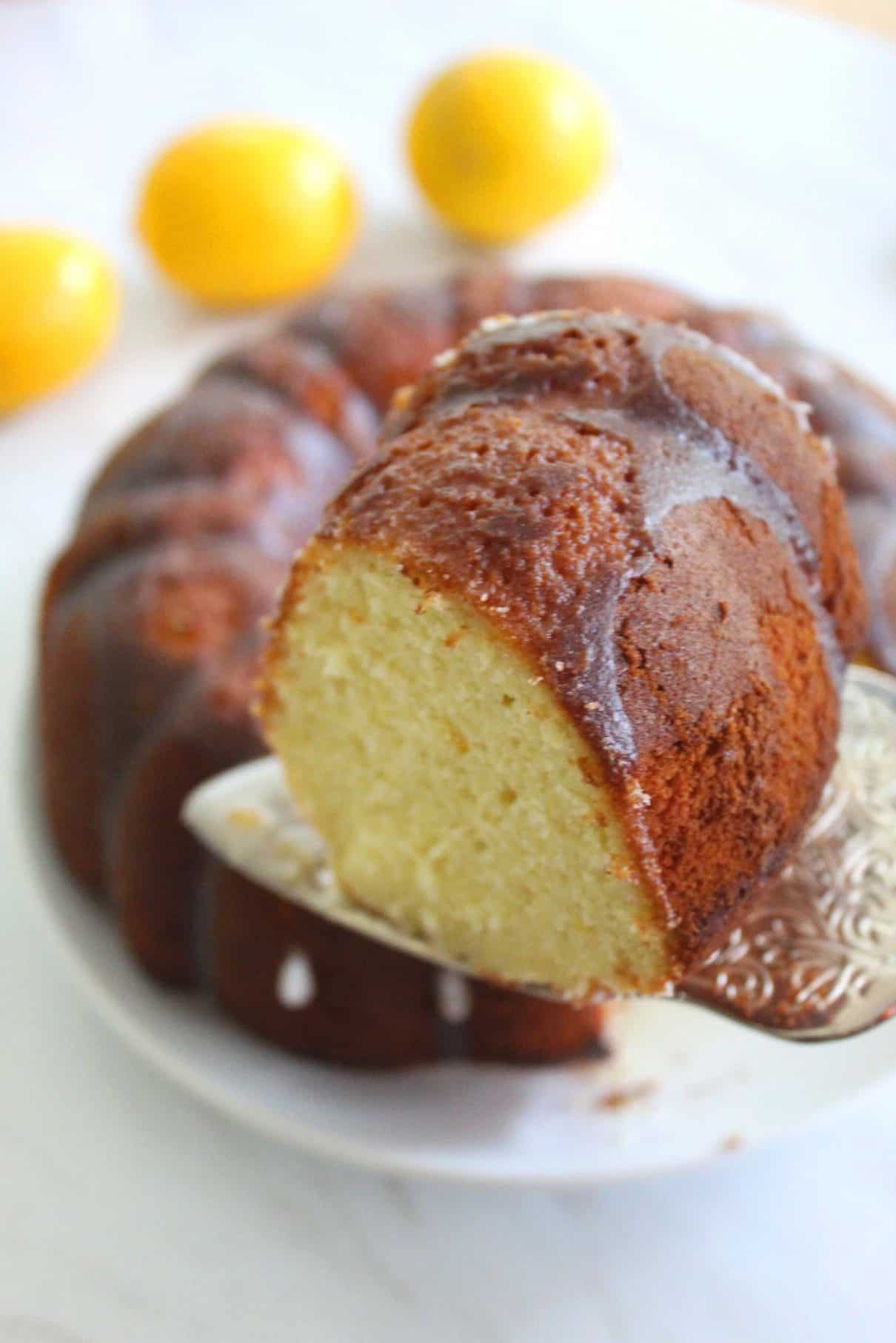 A slice of Lemon Bundt cake. The actual cake is in the back