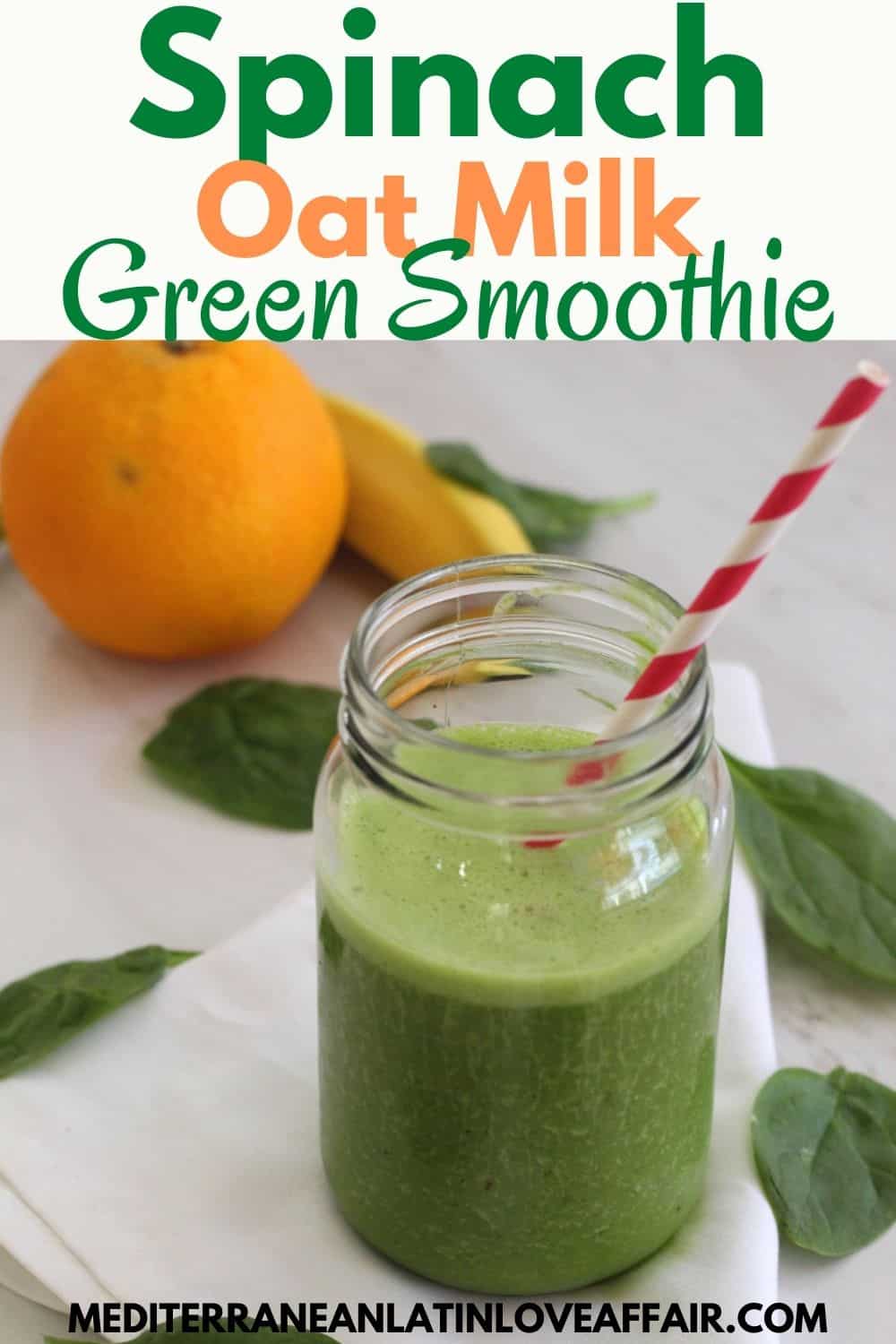 A jar with green smoothie over a white napkin. There are spinach leaves, an orange and a banana around the jar. 