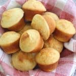 Cornbread muffins filled with cheese, over a serving basket lined with a napkin