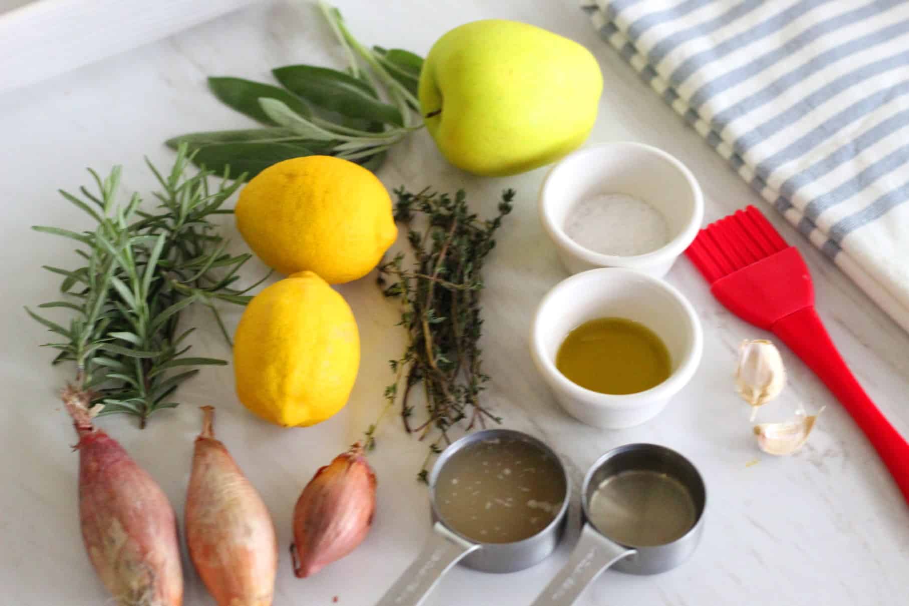 Ingredients needed to roast turkey breast: rosemary, sage, thyme, lemons, apple, coarse salt, olive oil, shallots, garlic chicken stock and white wine. 