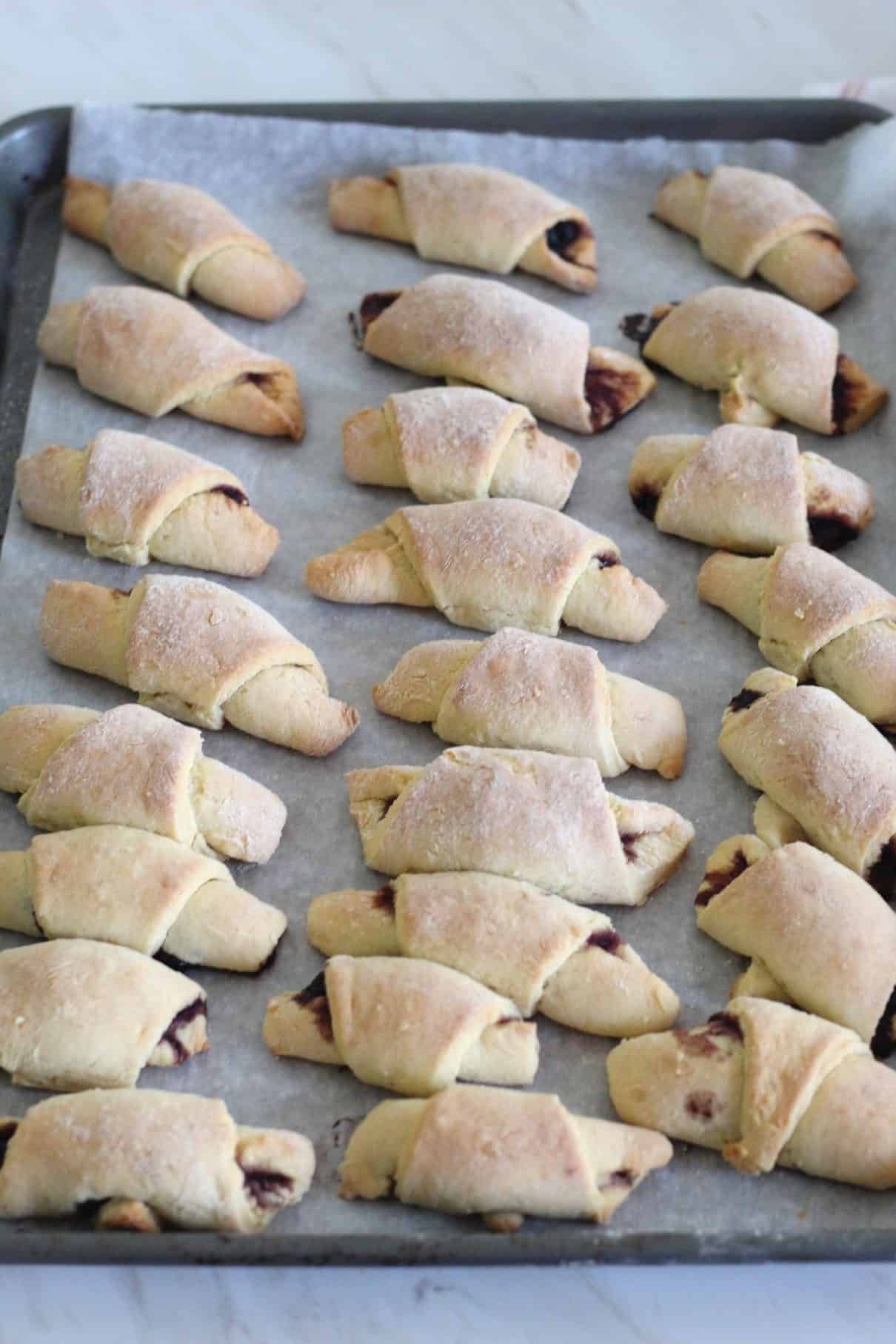 Just baked crescent rolled cookies on a baking sheet.
