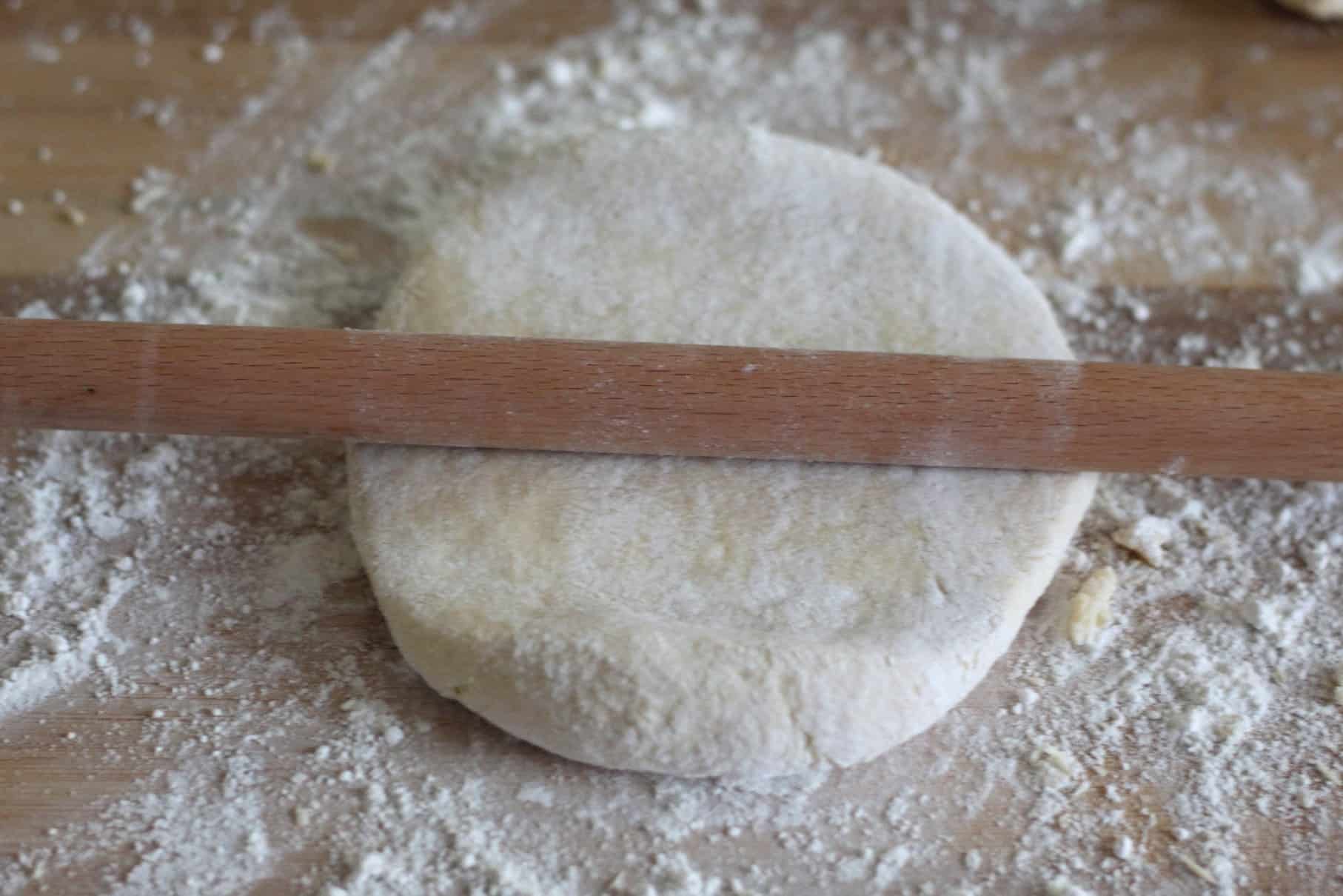 A big roll of dough flattened with a skinny rolling pin