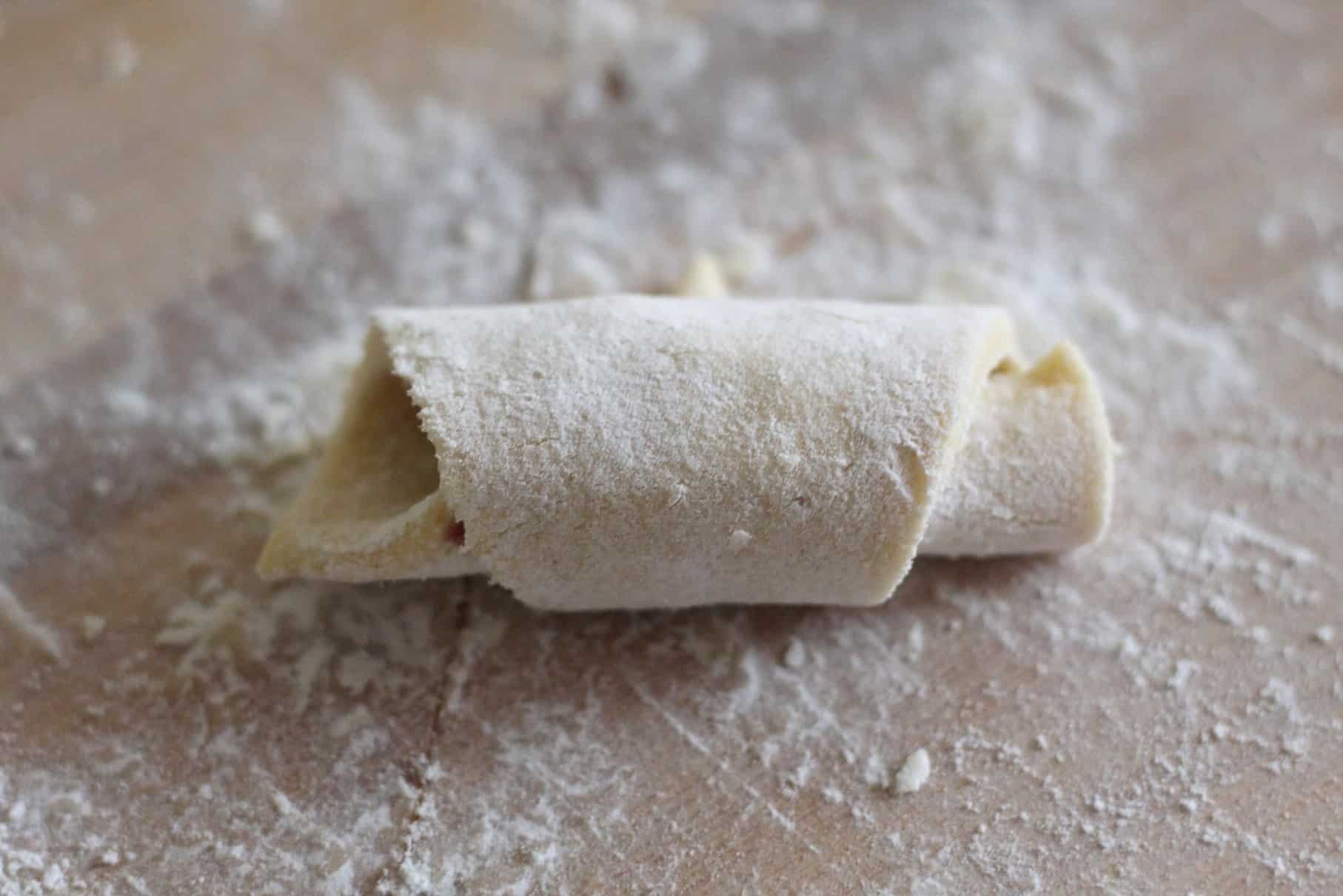 A rolled cookie, unbaked over a surface with flour