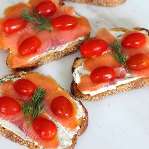 3 crostini with smoked salmon, cherry tomatoes and dill.