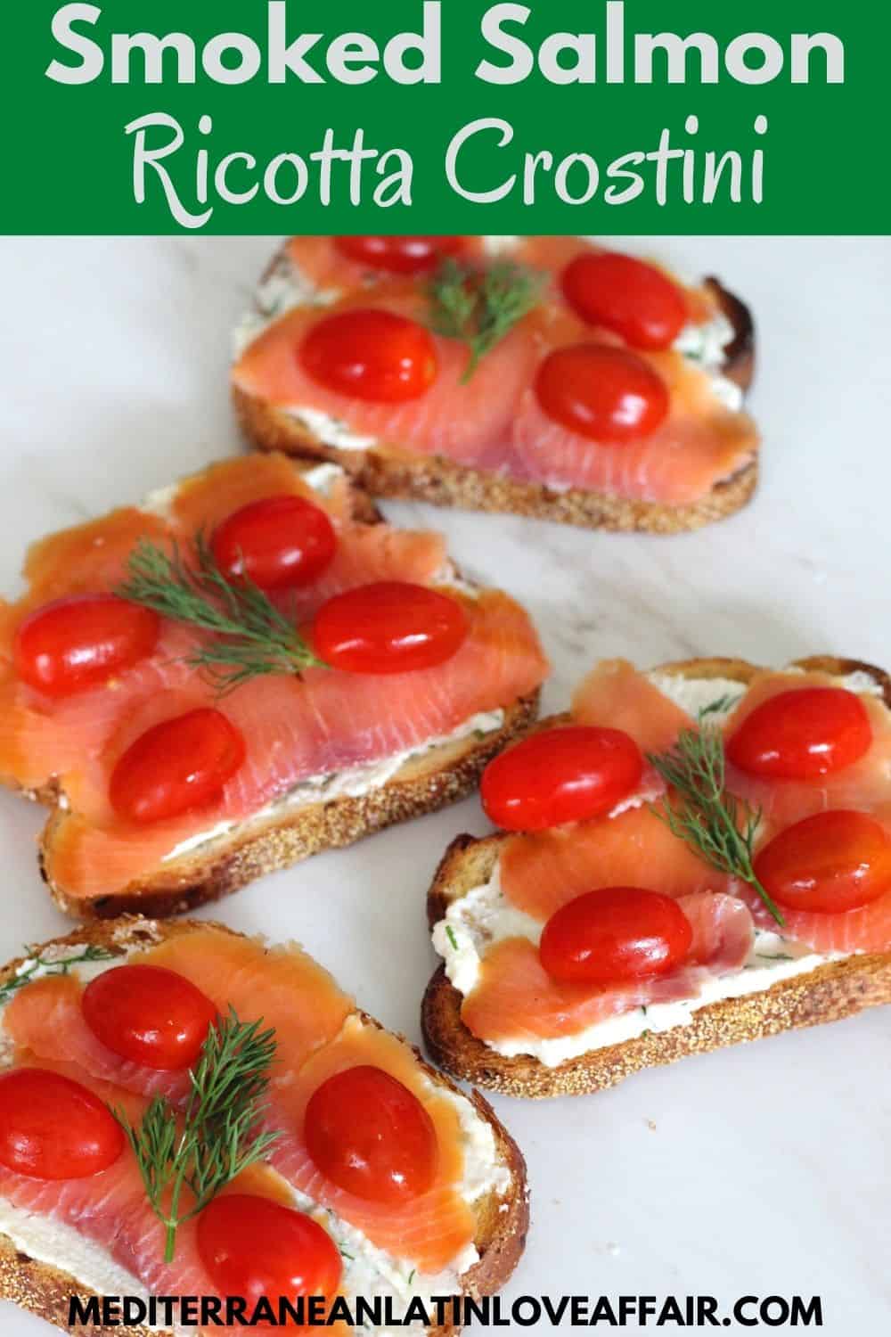 An image prepared for Pinterest. It shows the smoked salmon crostini in the center, a title bar on top of the picture and a website link at the bottom.
