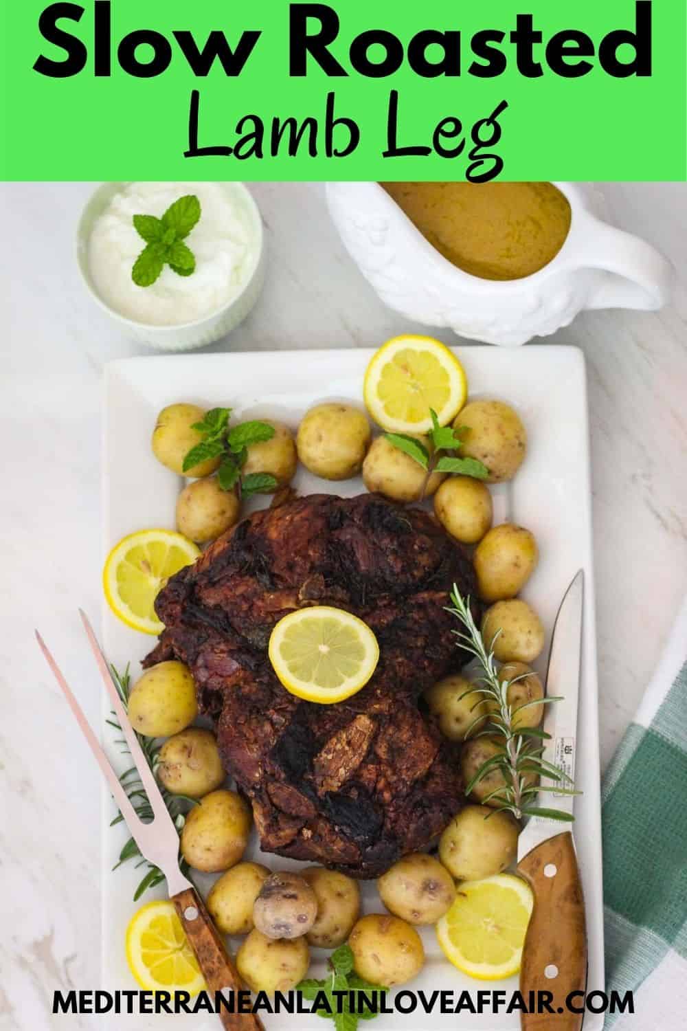 An image prepared for Pinterest. It shows the slow roasted lamb leg (boneless) served on a platter with potatoes, herbs and rosemary. Image has a title bar and the website link in the bottom.