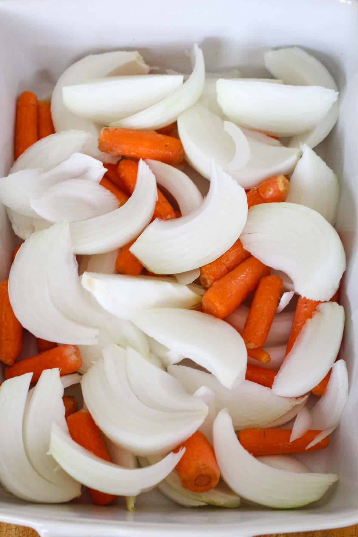 Chopped onions and carrots ready in the baking pan.