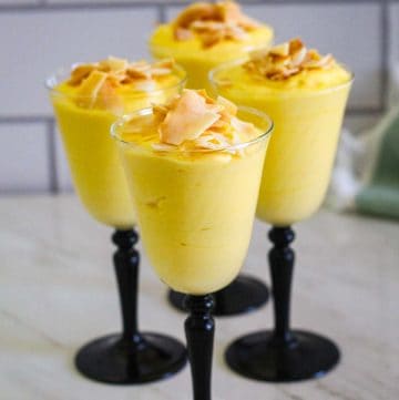 Served Mango Mousse on long liquor cups. Mousse is topped with coconut chips. Picture shows 4 cups.
