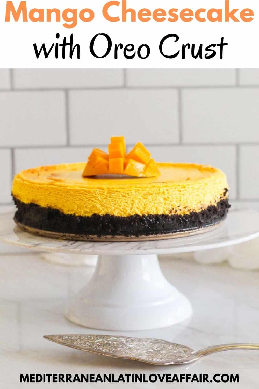 An image prepared for Pinterest, it shows the mango oreo cheesecake in the center of the image served on a white cake stand. On top of the picture there's a title bar and at the bottom a website link.