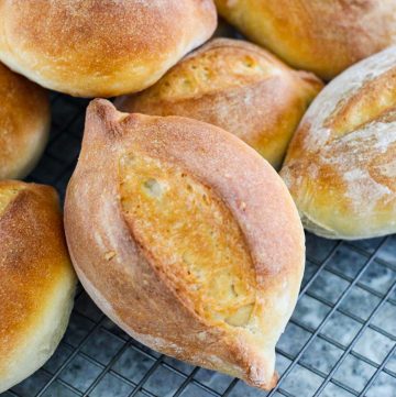 Crunchy Marraquetas bread rolls on a cooling rack