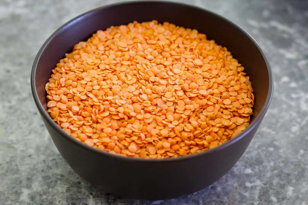 Dry red lentils before cooking, on a bowl.