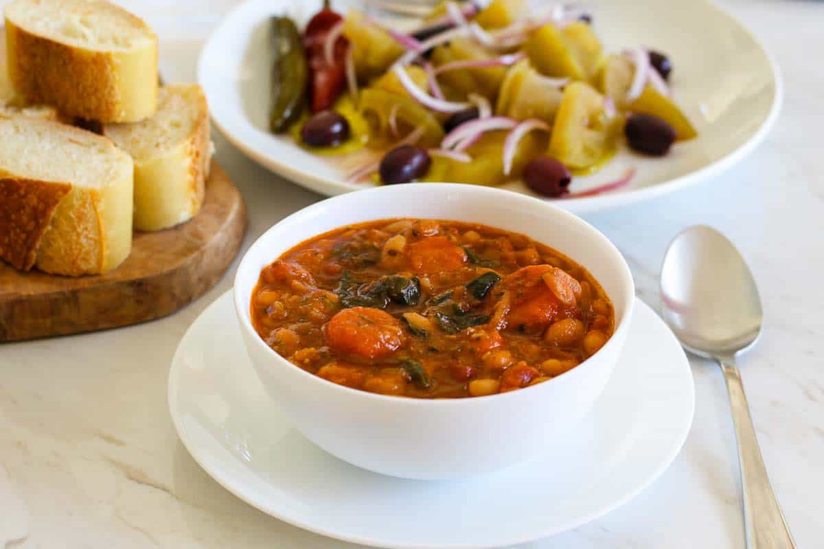 Beans soup served with green tomatoes and bread. 