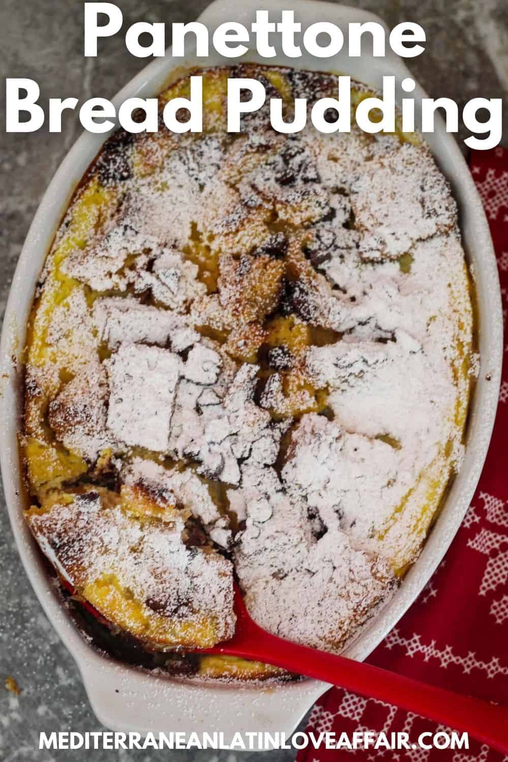 An image prepared specifically for Pinterest. It shows the baked Panettone bread pudding in a white oval dish. Pudding is covered in confectioner's sugar and there's a serving ladle cutting through for a serving. There's a title bar over the image and a website link in the bottom. 