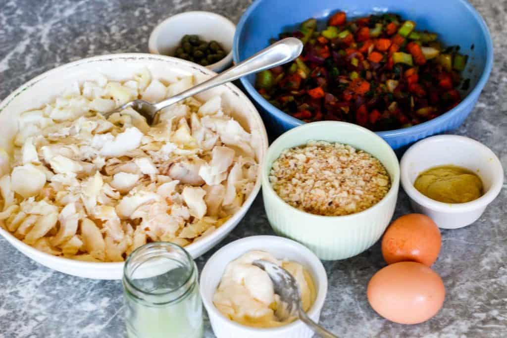 All the ingredients to make cod fish cakes: flaked cod, sauteed veggies, capers, bread crumbs, dijon mustard, eggs, lemon juice and mayo. 