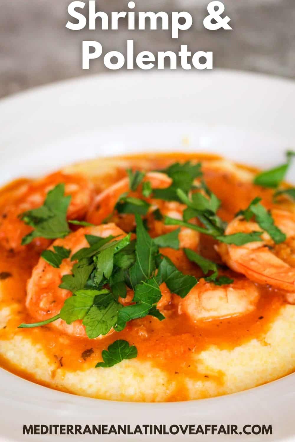Shrimp and polenta dish - food is already served on a white, round plate. This image is prepared for Pinterest because beside the image of food it shows a title bar on top and the website link in the bottom.
