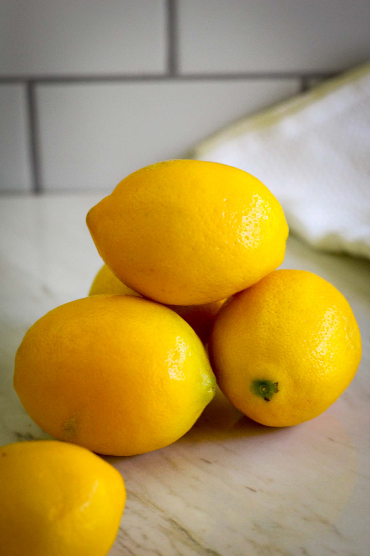 A picture showing a close up of 3-4 Meyer Lemons on a pile.
