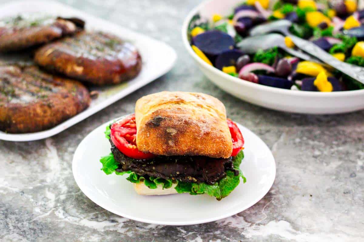 Grilled portobello mushrooms burger with a side of salad.