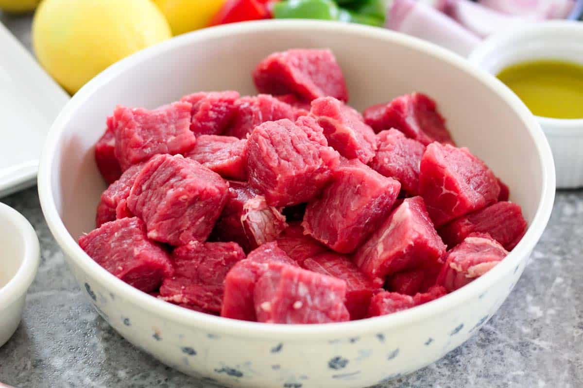 Beef cut in 1 inch cubes for kebabs. Meat is in a round bowl.