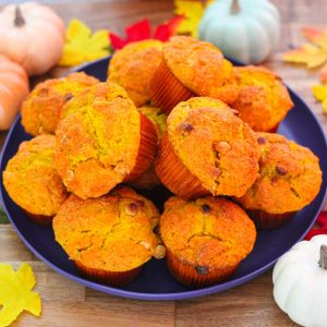 A round blue plate showing lots of pumpkin muffins on top, surrounded by Fall decor.