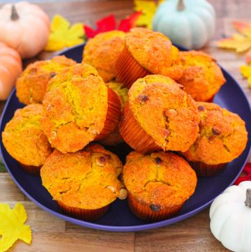 A round blue plate showing lots of pumpkin muffins on top, surrounded by Fall decor.