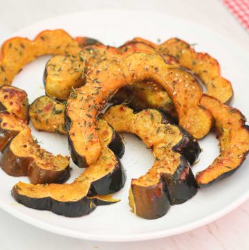 A plate with za'atar roasted acorn squash slices. They're naturally waving and look so pretty and appetizing.