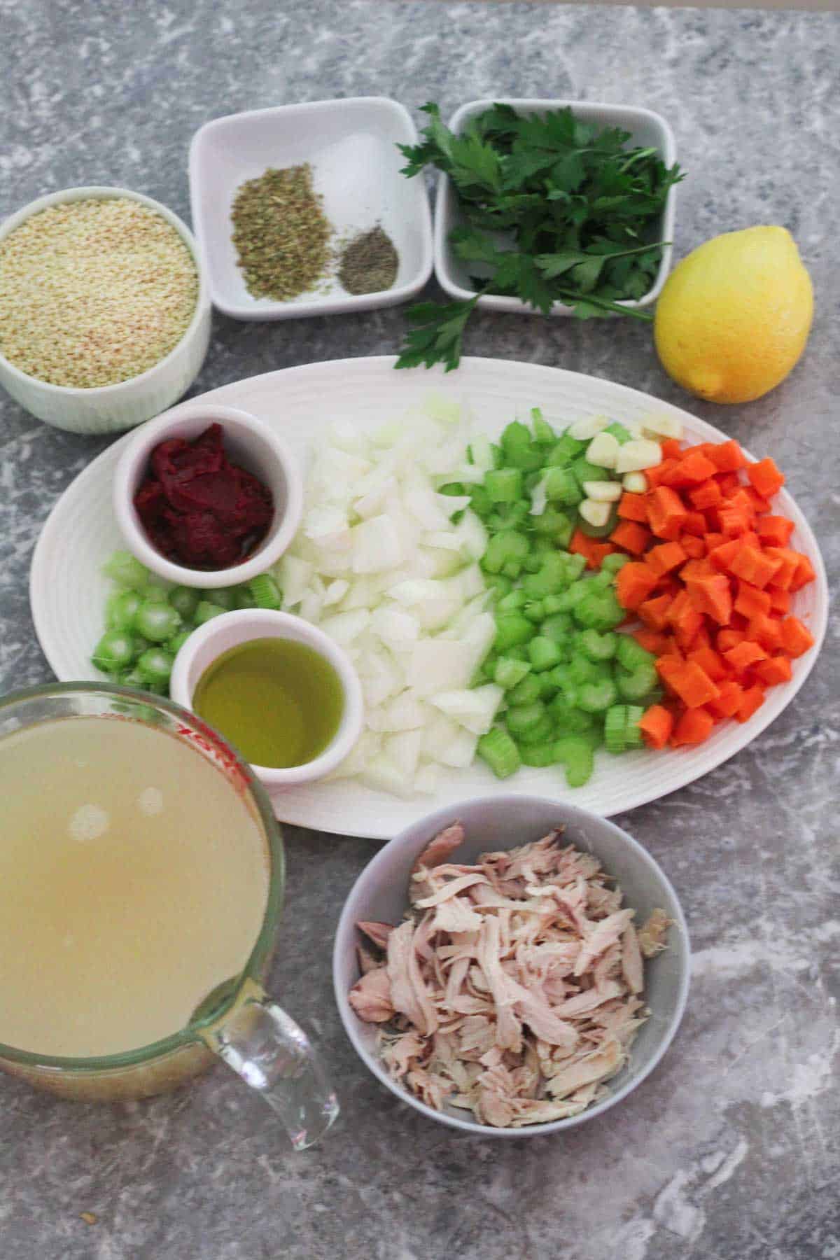 Ingredients for pastina soup: shredded chicken, chicken stock, olive oil, onions, celery, carrots, fennel, tomato paste, pastina, salt, pepper, oregano, fresh parsley, lemon, garlic. 