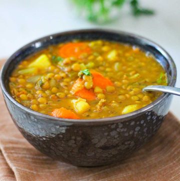 A bowl of lentils soup with ham.
