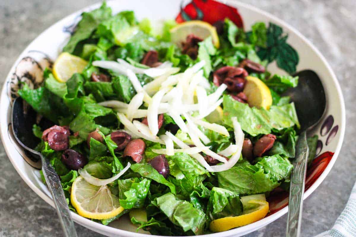Green salad with lemons, olives and onions.