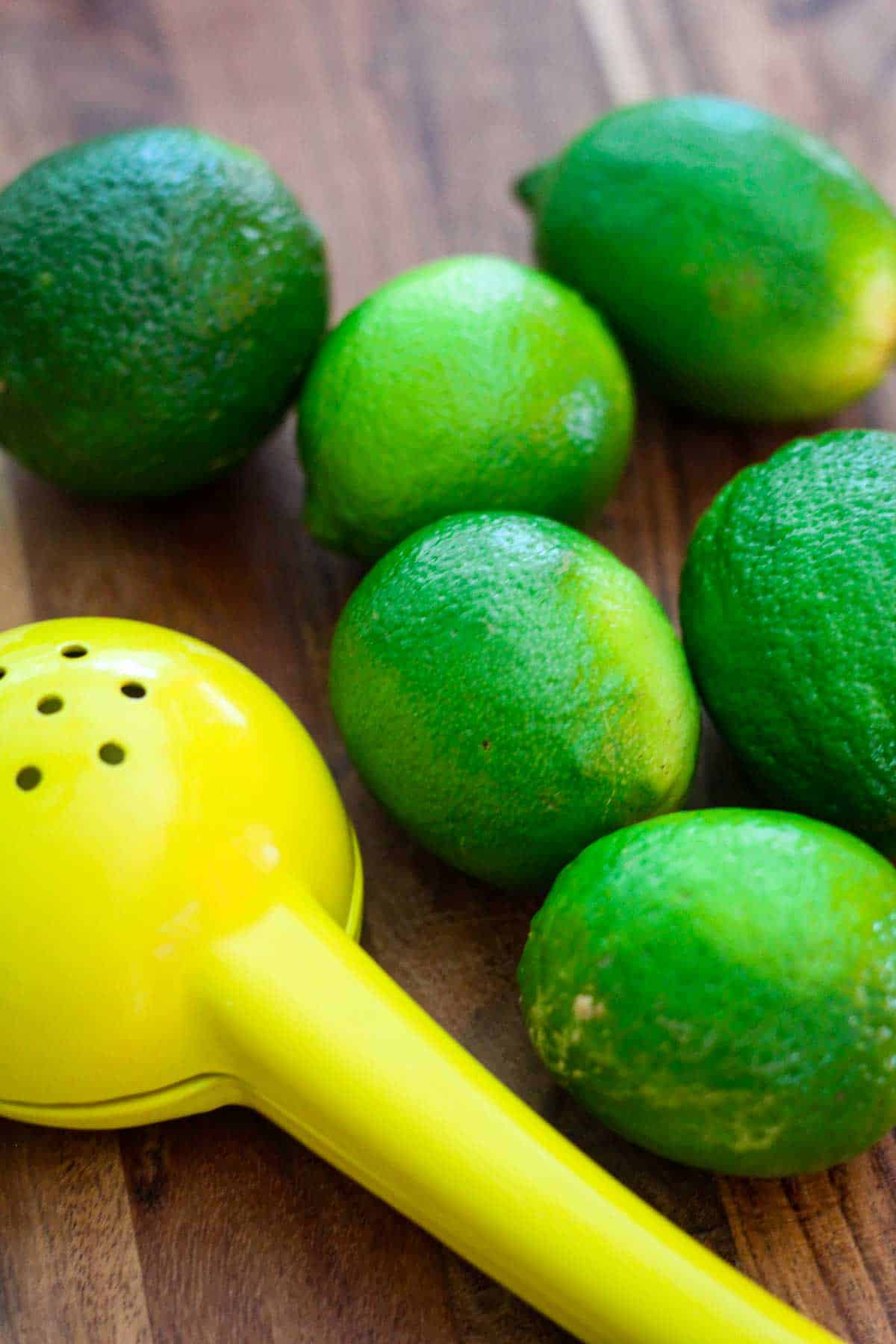 Limes next to a citrus squeezer, ready to make ceviche.