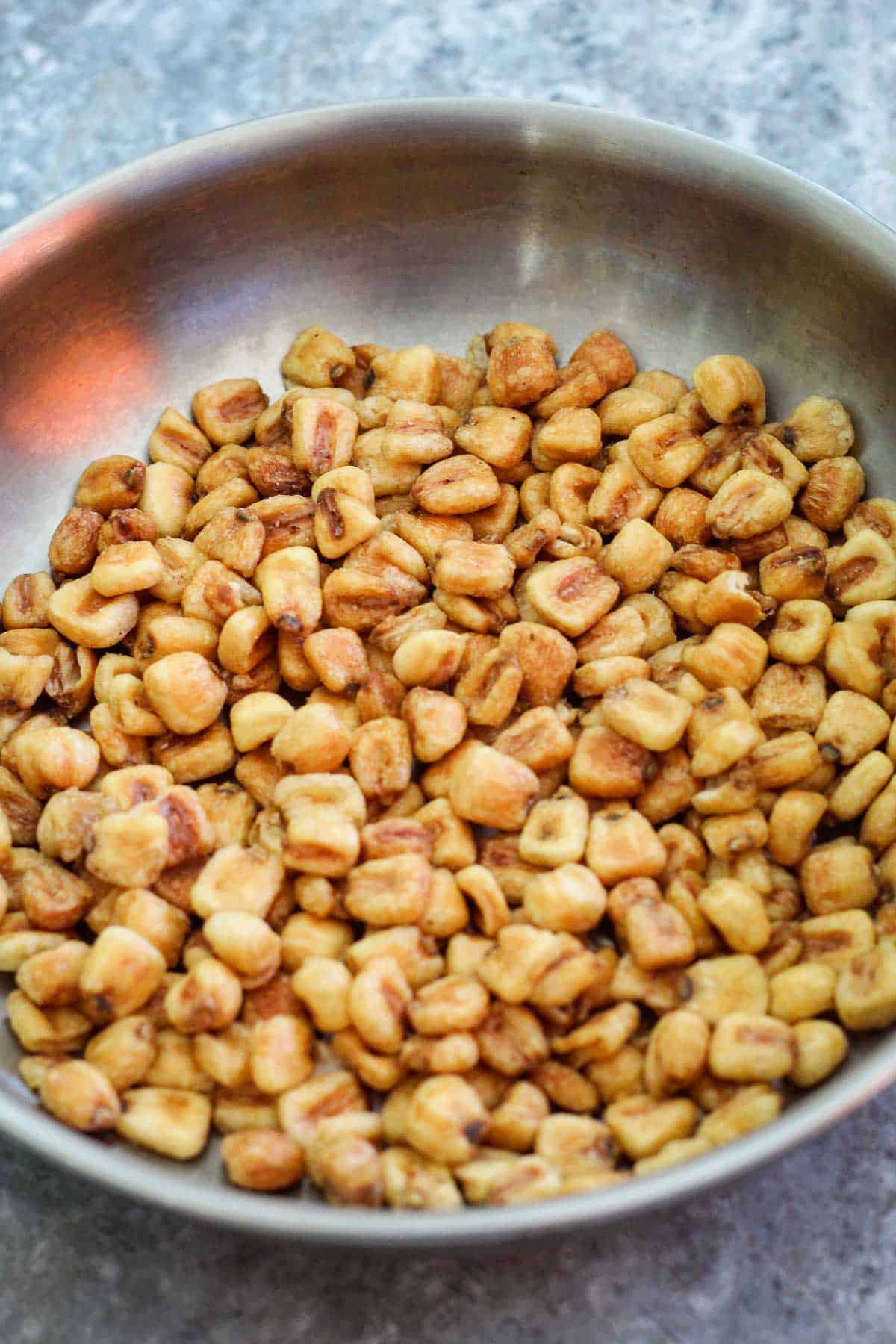 A skillet showing toasted corn.